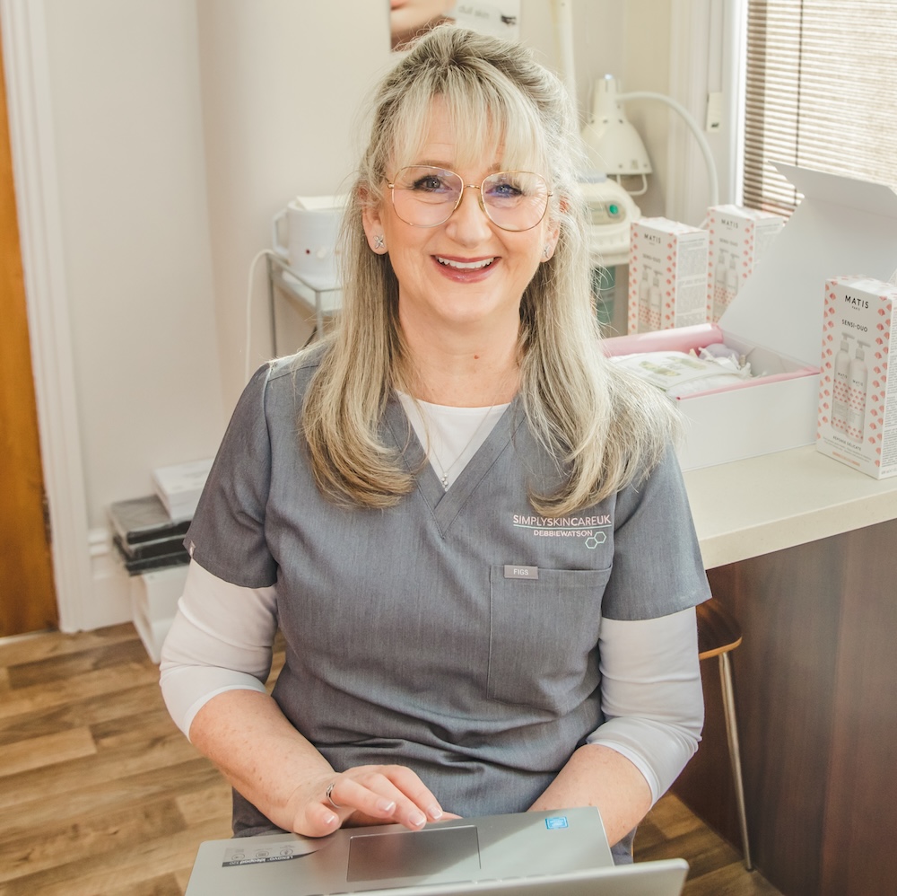 Debbie Watson is pictured in her treatment room. She is looking at the camera and smiling.